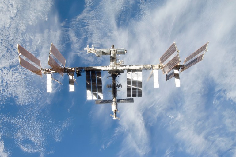 september 8, 2009 - backdropped by a blue and white part of earth, the international space station is seen from space shuttle discovery as the two spacecraft begin their relative separation.