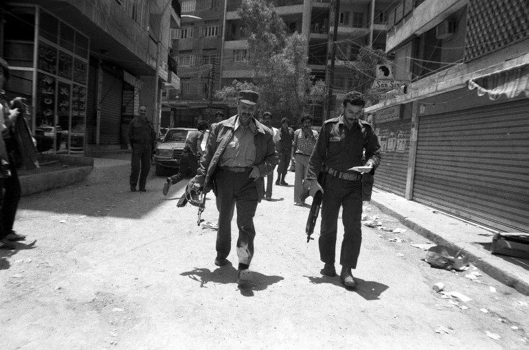 ياسر عرفات (يسار) حاملاً سلاحه في بيروت عام 1982 (غيتي)