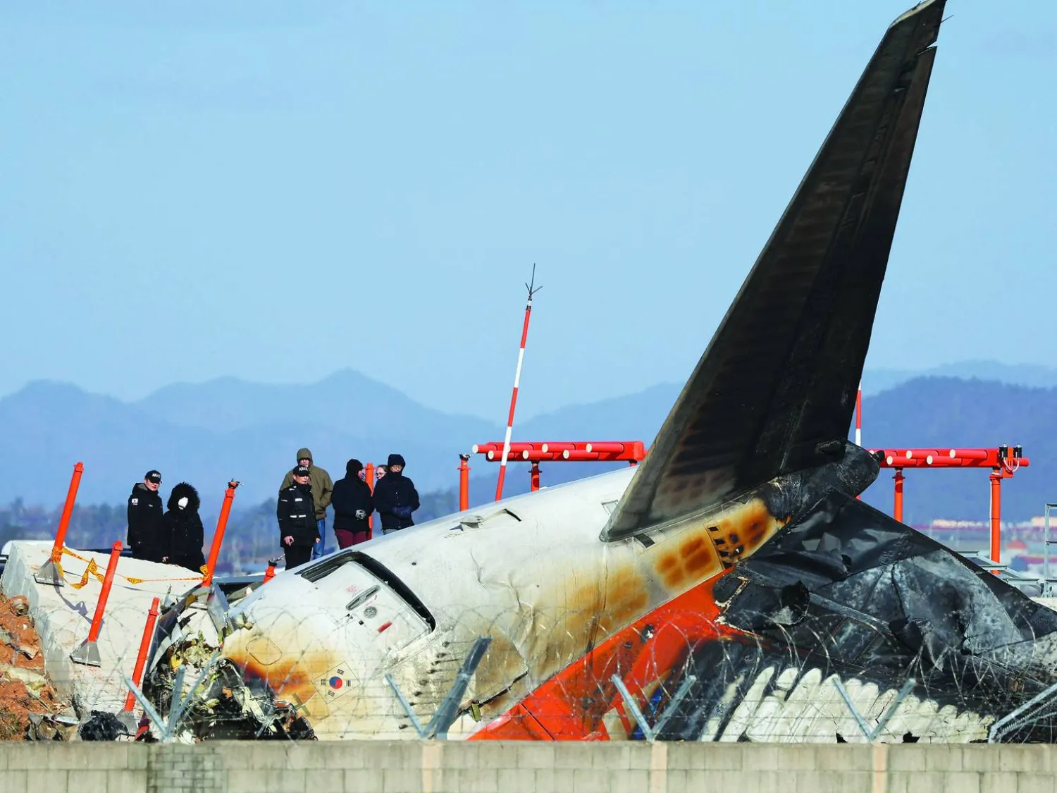 محققون من كوريا الجنوبية ومسؤولون من «ntsb» وشركة «بوينغ» يتفقدون مكان تحطم الطائرة في مطار موان على بعد 288 كيلومتراً جنوب غربي سيول (أ.ف.ب)