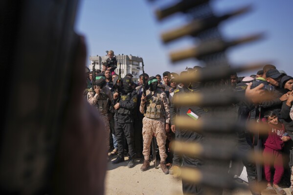 hamas and islamic jihad fighters contain the crowd as cars carrying israeli gadi mozes and arbel yahoud, who have been held hostages by hamas in gaza since october 7, 2023, are escorted to be handed over to the red cross in khan younis, southern gaza strip, thursday jan. 30, 2025.(ap photo/abdel kareem hana)
