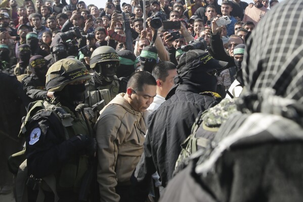 two thai captives, who has been held hostage by hamas in gaza since october 7, 2023, are escorted by hamas fighters as they are handed over to the red cross in khan younis, southern gaza strip, thursday jan. 30, 2025.(ap photo/jehad alshrafi)