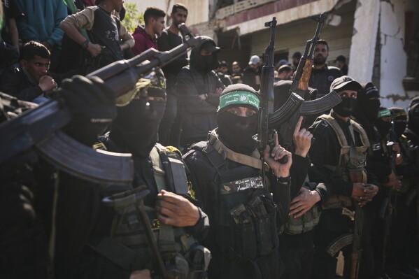 hamas and islamic jihad fighters hold their weapons as cars carrying israeli gadi mozes and arbel yahoud, who have been held hostages by hamas in gaza since october 7, 2023, are escorted to be handed over to the red cross in khan younis, southern gaza strip, thursday jan. 30, 2025.(ap photo/abdel kareem hana)