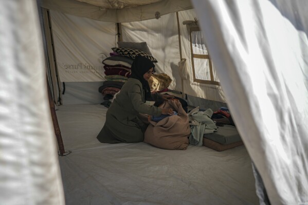 majida abu jarad packs belongings as she prepares to go back to the family's home in the north, at a camp for displaced palestinians in the muwasi area, southern gaza strip, saturday, jan. 18, 2025. (ap photo/abdel kareem hana)